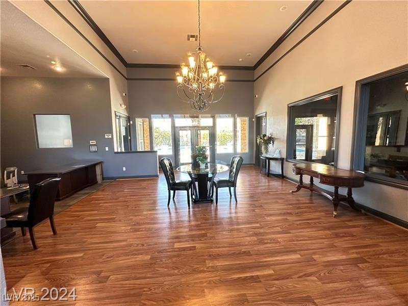 6650 West Warm Springs Road, Unit 2007 Las Vegas, NV 89118 - Photo 22 of 26 Dining room with a towering ceiling, crown molding, wood finished floors, and a chandelier