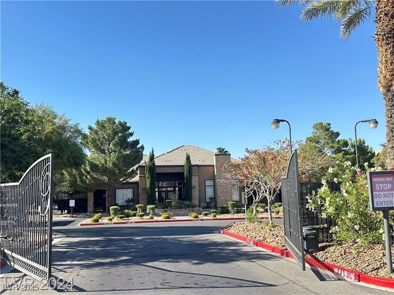 6650 West Warm Springs Road, Unit 2007 Las Vegas, NV 89118 - Photo 4 of 26 View of asphalt road with curbs, a gated entry, and street lights