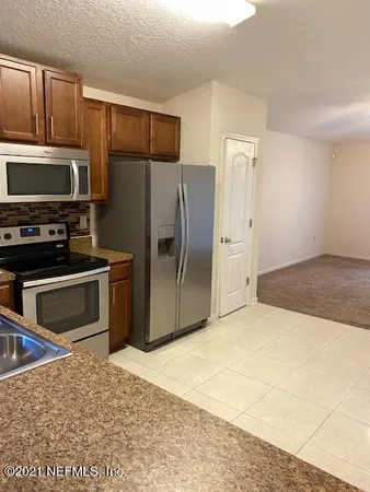 a kitchen with stainless steel appliances kitchen island granite countertop a refrigerator and a stove top oven