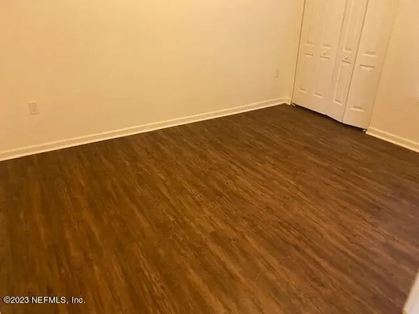a view of an empty room with wooden floor