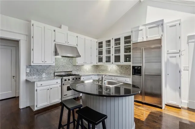 a kitchen with stainless steel appliances granite countertop a sink stove and refrigerator
