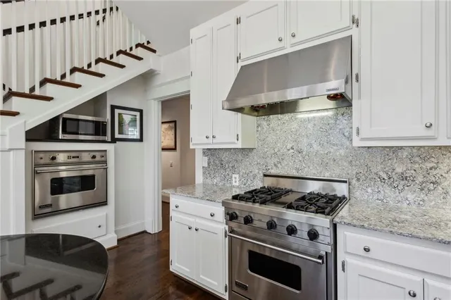 a kitchen with cabinets appliances and wooden floor