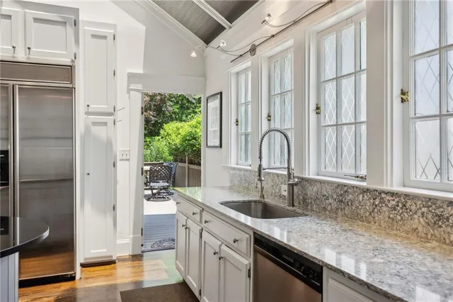 a kitchen with stainless steel appliances granite countertop a sink and a refrigerator