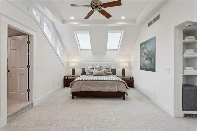 a spacious bedroom with a bed and a chandelier
