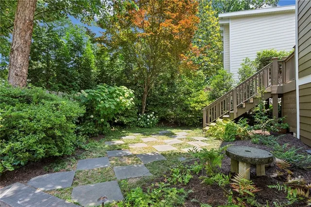 a view of yard with small fountain plants and large trees