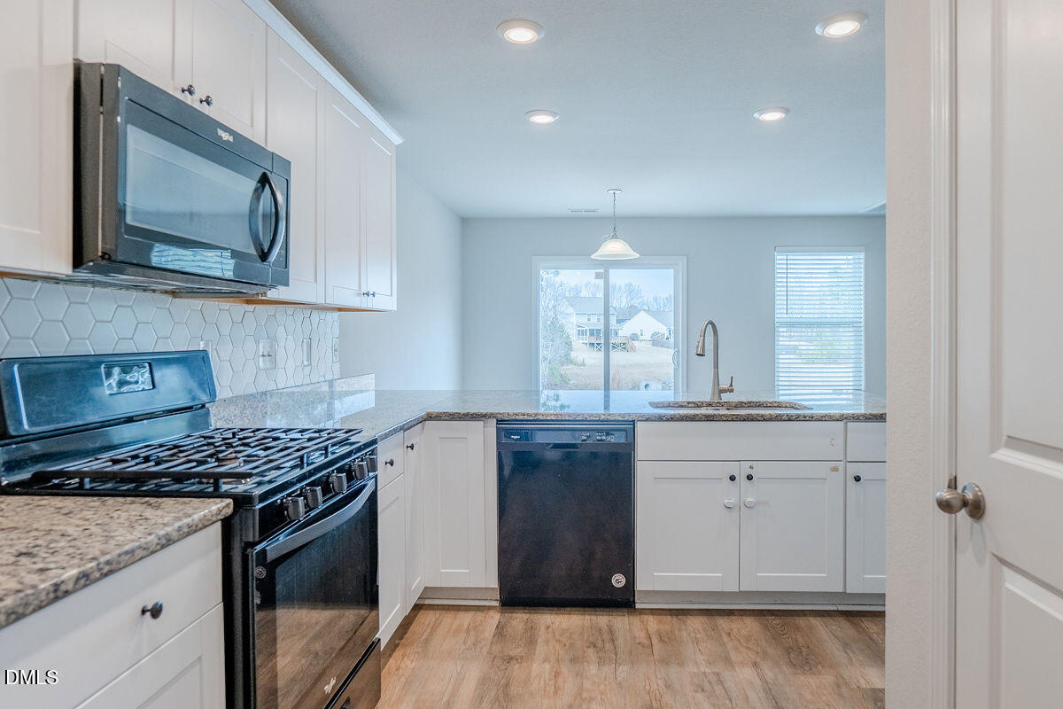 2036 Alderman Way Creedmoor, NC 27522 - Photo 12 of 49 a kitchen with stainless steel appliances granite countertop a stove and a microwave