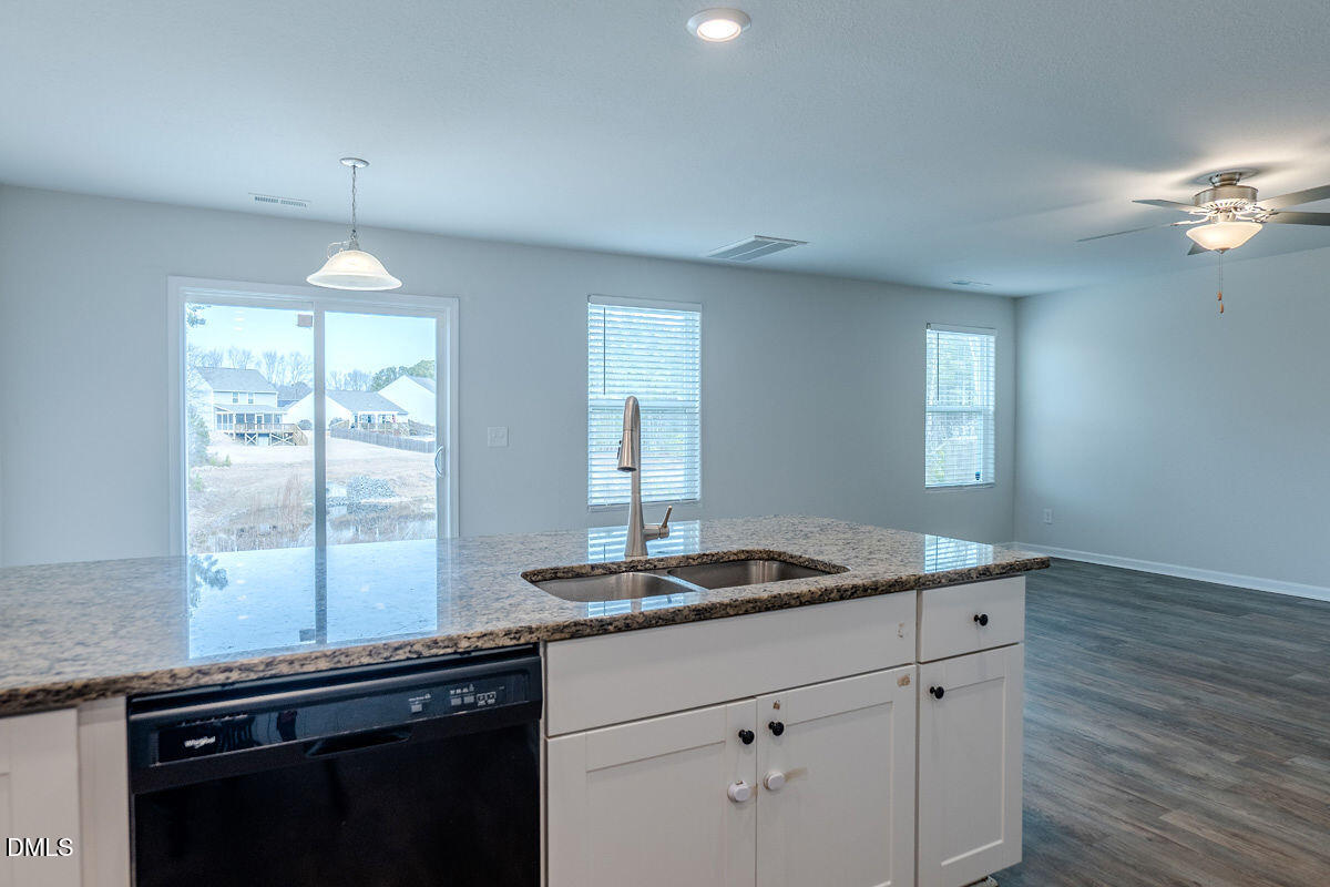 2036 Alderman Way Creedmoor, NC 27522 - Photo 18 of 49 a kitchen with kitchen island granite countertop a sink cabinets and wooden floor