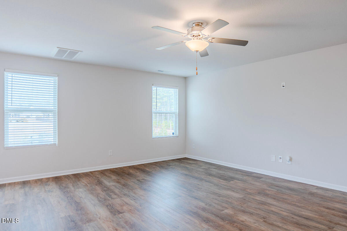 2036 Alderman Way Creedmoor, NC 27522 - Photo 19 of 49 an empty room with wooden floor fan and windows