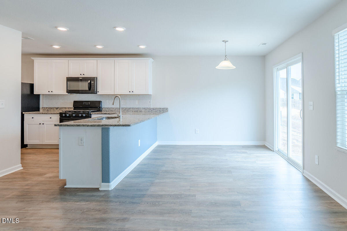 2036 Alderman Way Creedmoor, NC 27522 - Photo 23 of 49 a large kitchen with stainless steel appliances granite countertop a stove a sink and a microwave