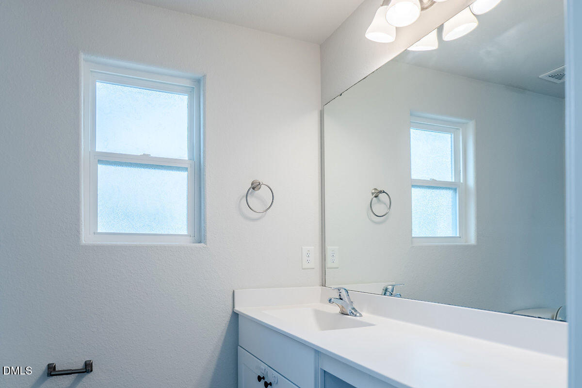 2036 Alderman Way Creedmoor, NC 27522 - Photo 26 of 49 a bathroom with a sink a mirror and a window