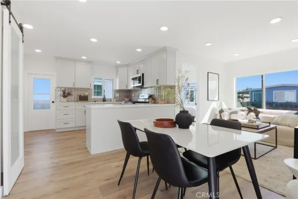 a dining room with stainless steel appliances kitchen island granite countertop a dining table chairs and view kitchen