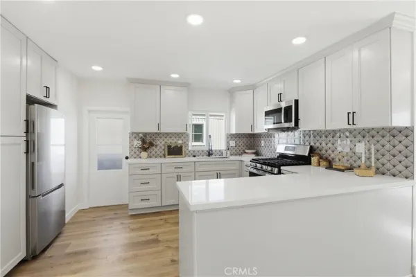 a kitchen with kitchen island a white cabinets and refrigerator