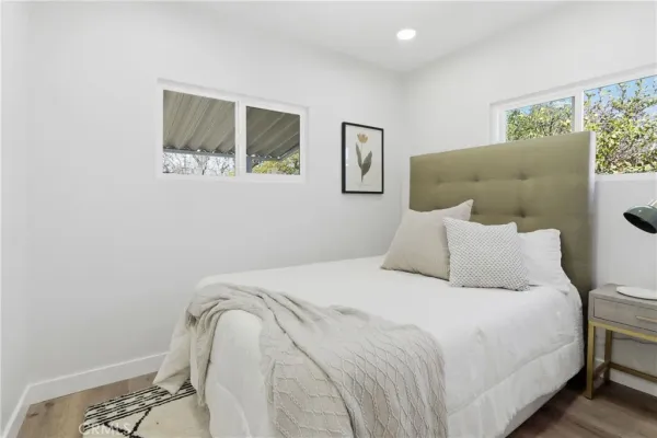 a bedroom with a bed and painting on the wall