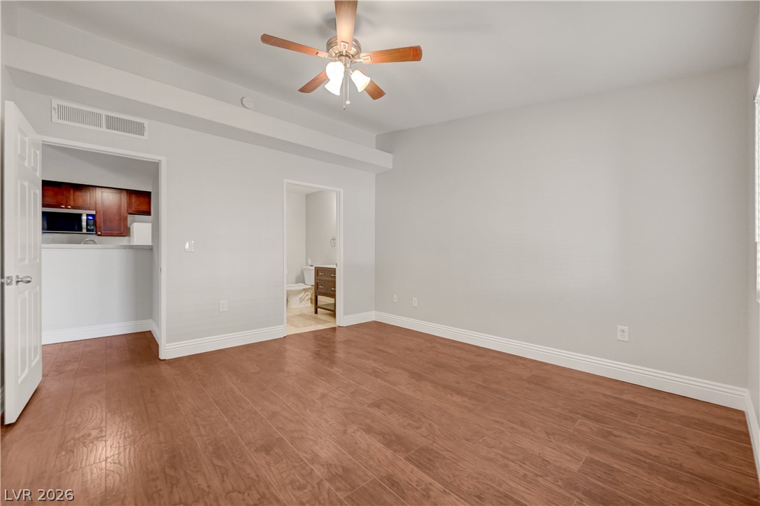 7885 West Flamingo Road, Unit 1050 Las Vegas, NV 89147 - Photo 21 of 62 Rich hardwood flooring stretches across this naturally illuminated, spacious interior with a tasteful ceiling fan.