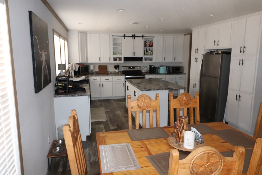 20120 Other Rocksprings, TX 78880 - Photo 11 of 20 a kitchen with stainless steel appliances granite countertop a refrigerator a stove a sink a dining table and chairs