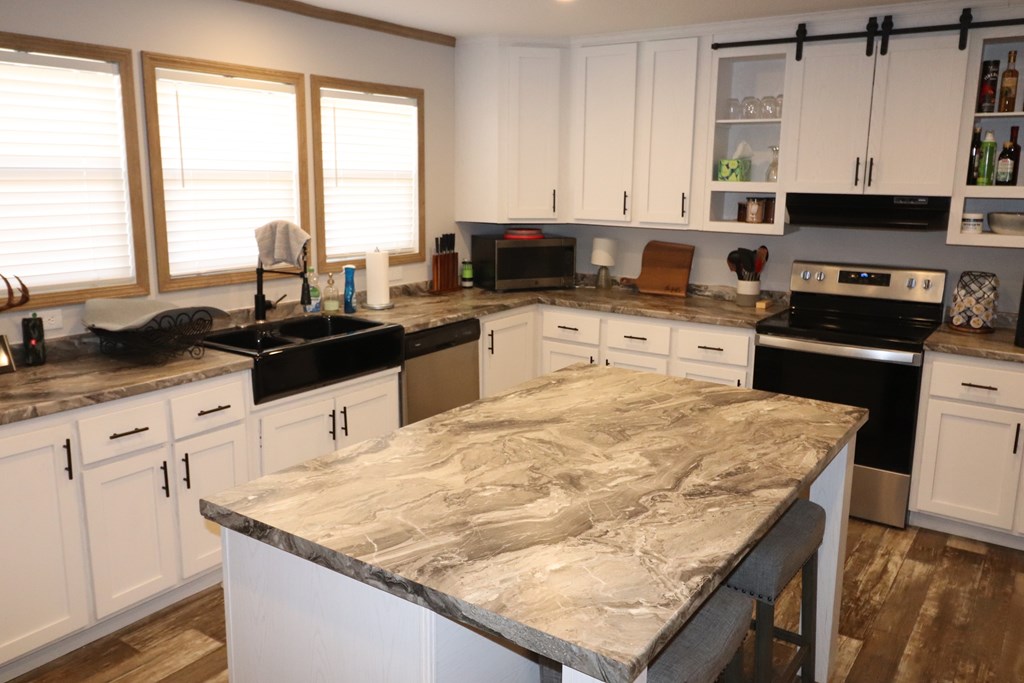 20120 Other Rocksprings, TX 78880 - Photo 13 of 20 a kitchen with granite countertop sink stove and white cabinets