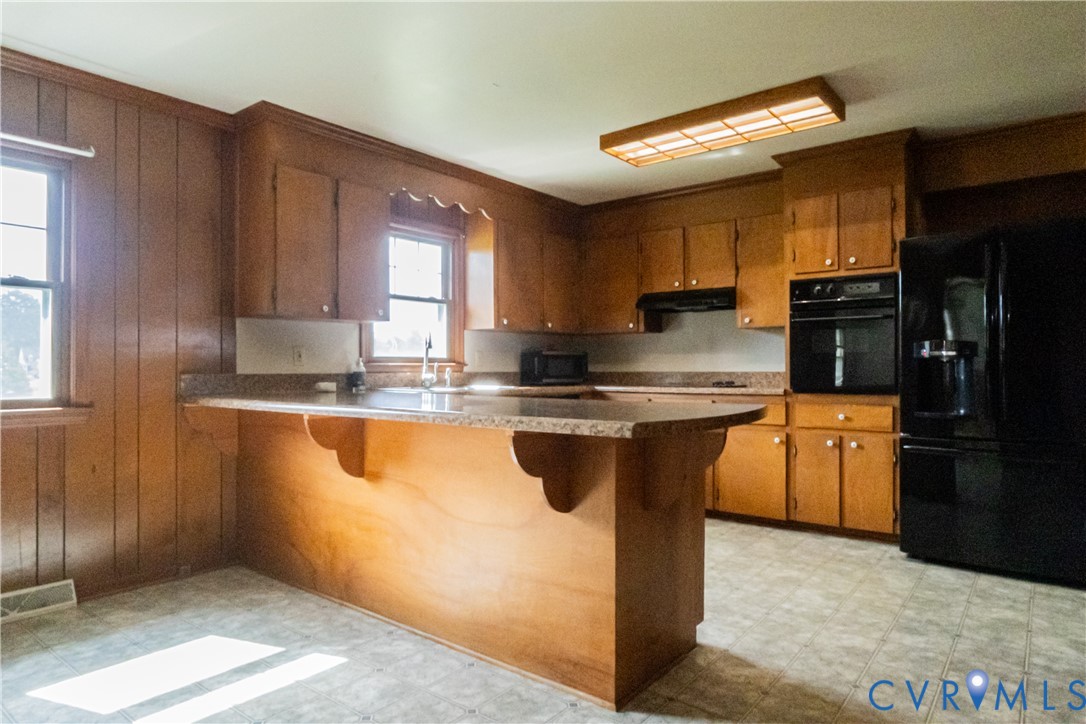 309 Old Plank Road Kenbridge, VA 23944 - Photo 20 of 45 Kitchen featuring wood-paneled walls, wood cabinet