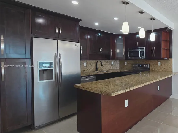 a kitchen with kitchen island a counter top stainless steel appliances and cabinets