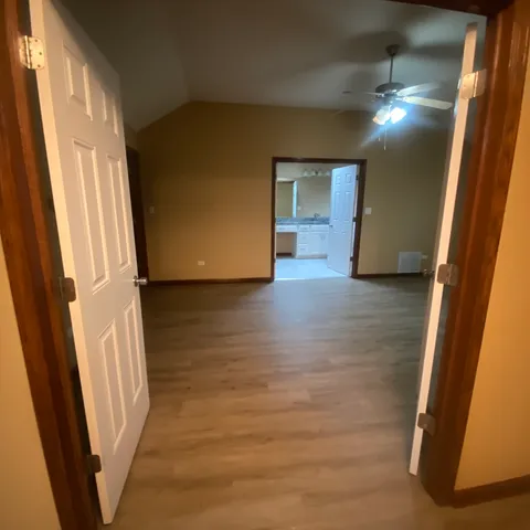 a view of a hallway with wooden floor and stairs