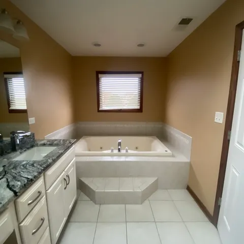a bathroom with a tub sink and mirror