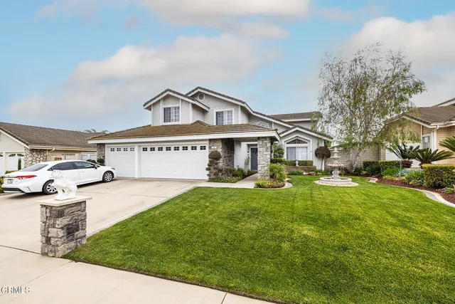 a view of a big house with a big yard and large trees
