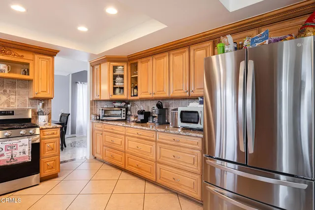 a kitchen with stainless steel appliances a refrigerator sink and cabinets