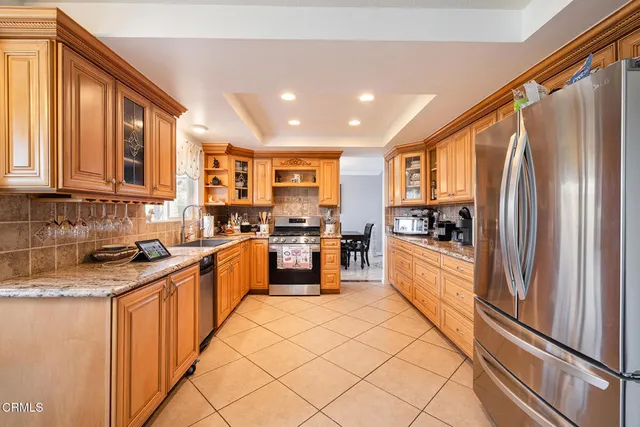 a kitchen with stainless steel appliances granite countertop a refrigerator and a stove top oven