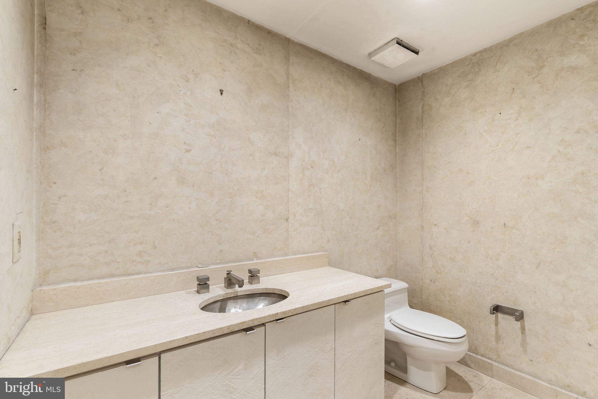 2301 Cherry Street, Unit 6F Philadelphia, PA 19103 - Photo 4 of 30 a bathroom with a granite countertop sink and a toilet