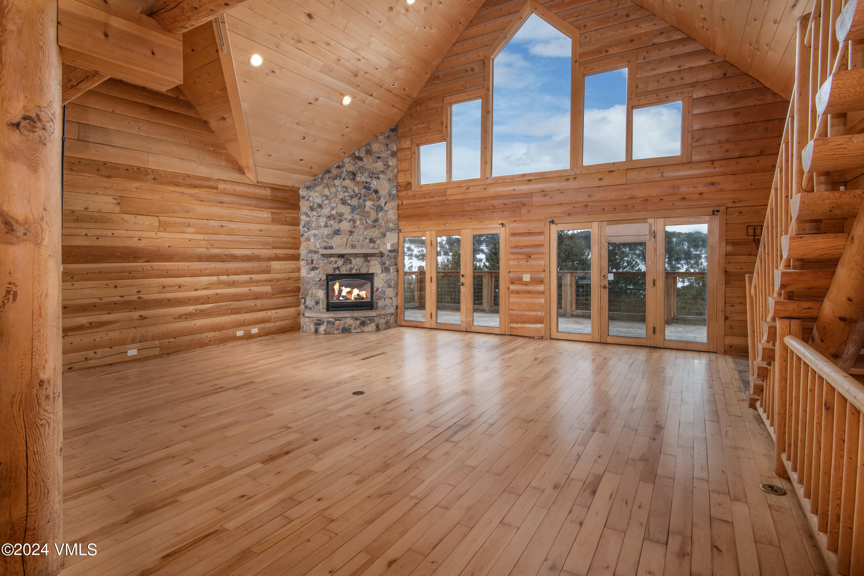 an empty room with wooden floor and a fireplace