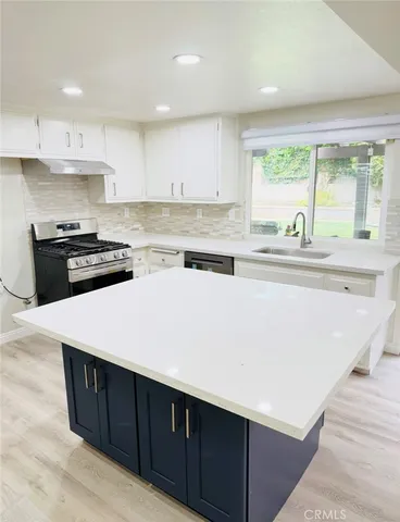 a kitchen with stainless steel appliances sink cabinets and wooden floor
