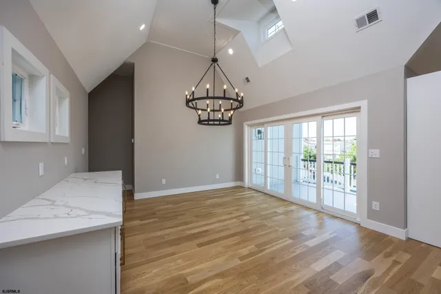 a view of hallway with wooden floor and chandelier