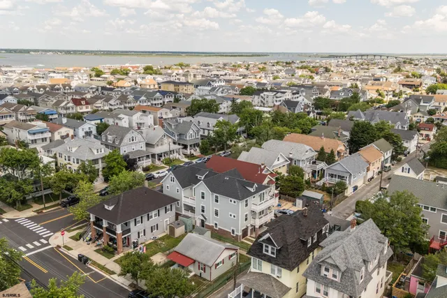 an aerial view of a city with ocean view in back