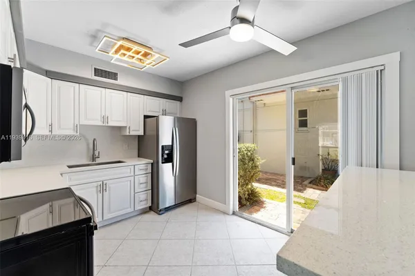 a kitchen with stainless steel appliances granite countertop a refrigerator and a sink