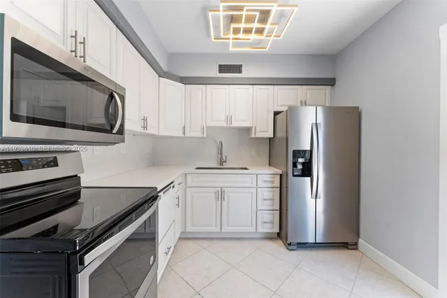 a kitchen with stainless steel appliances a refrigerator sink and microwave