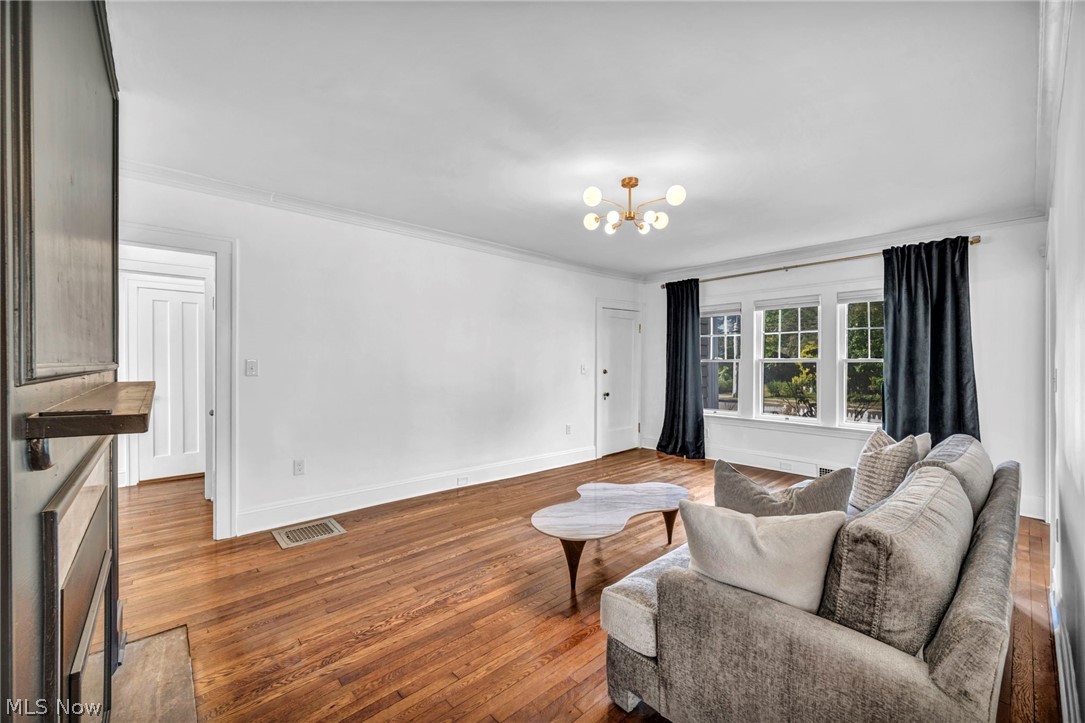 2135 Coventry Road, Unit DOWN Cleveland, OH 44118 - Photo 6 of 34 Living area featuring suspended lighting, dark wood-style floors, and ornamental molding