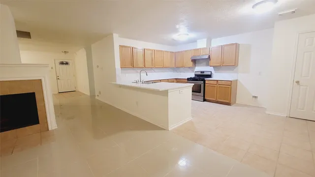 a kitchen with stainless steel appliances granite countertop a stove top oven a sink a counter space and cabinets