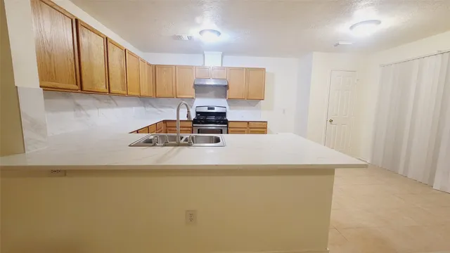a kitchen with sink a refrigerator and cabinets