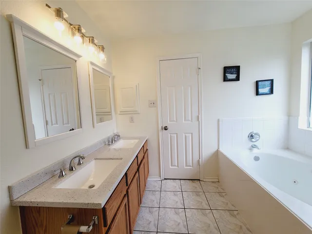 a bathroom with a tub sink and mirror