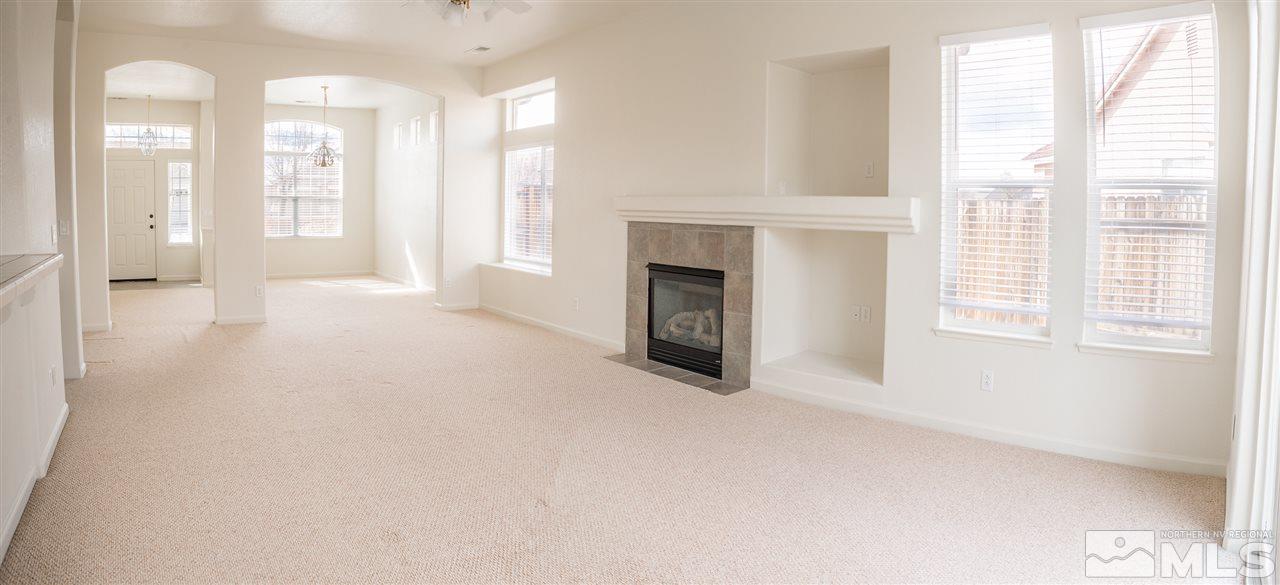 10490 Arbor Way Reno, NV 89521 - Photo 4 of 23 a view of an empty room with a fireplace and a window
