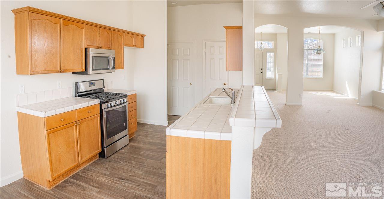 10490 Arbor Way Reno, NV 89521 - Photo 6 of 23 a kitchen with stainless steel appliances granite countertop a stove and a sink