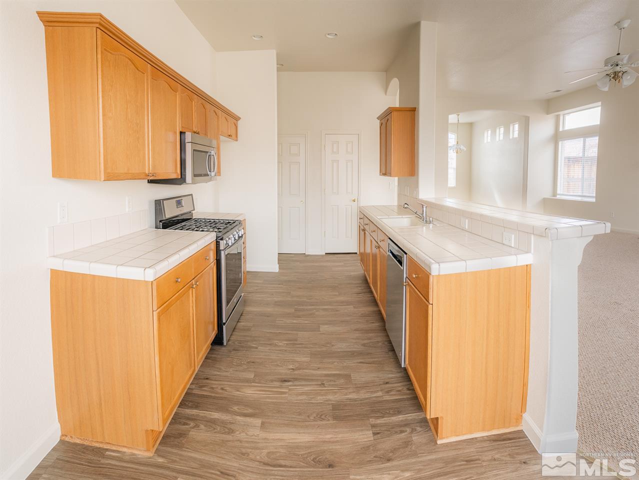10490 Arbor Way Reno, NV 89521 - Photo 7 of 23 a kitchen with a sink and wooden cabinets