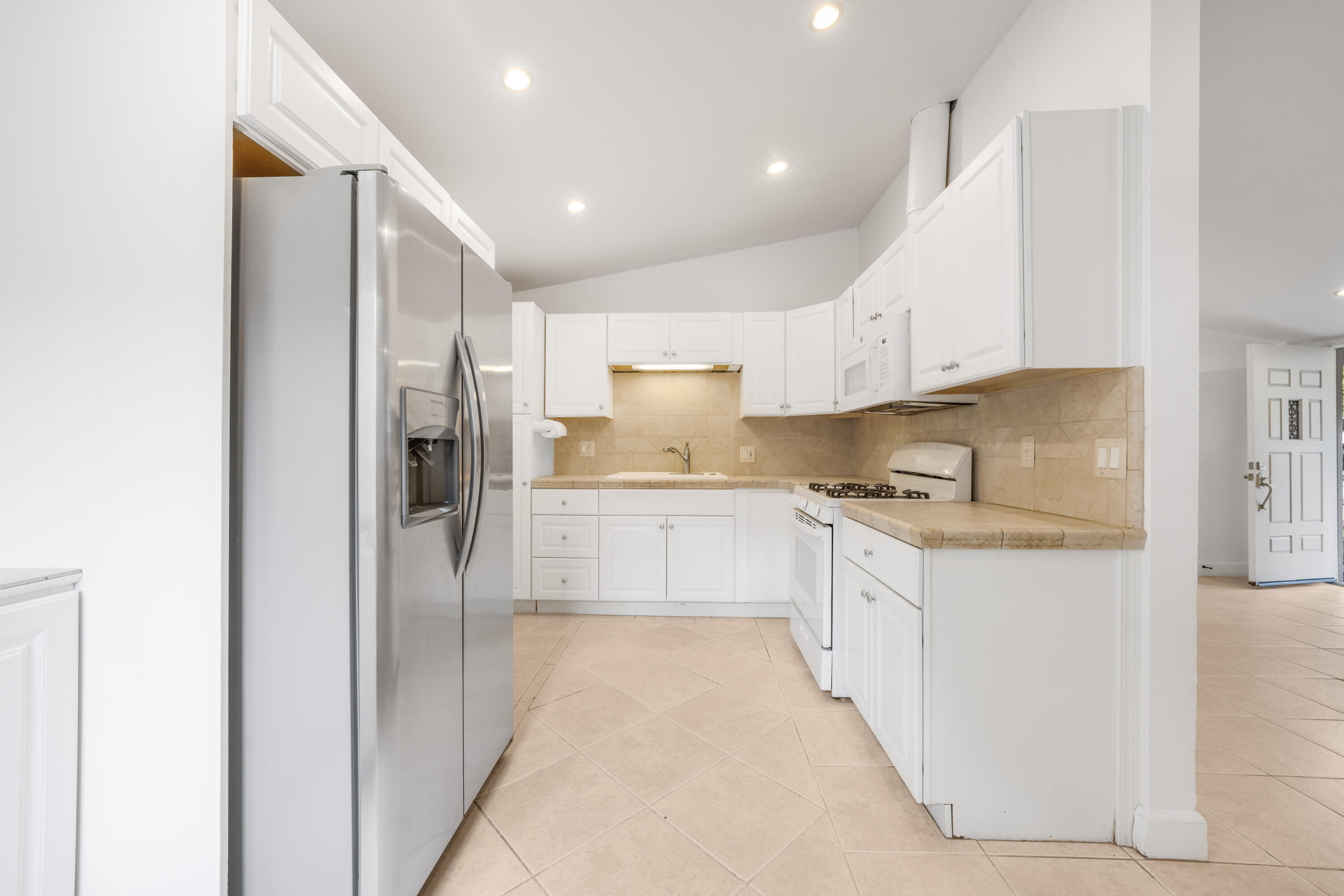 901 Fellowship Road Santa Barbara, CA 93109 - Photo 11 of 44 a large kitchen with stainless steel appliances kitchen island granite countertop a refrigerator and a stove top oven