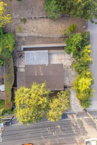 a view of house with backyard and trees in the background