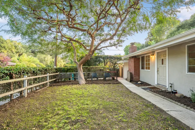 a view of a house with a large tree and a yard