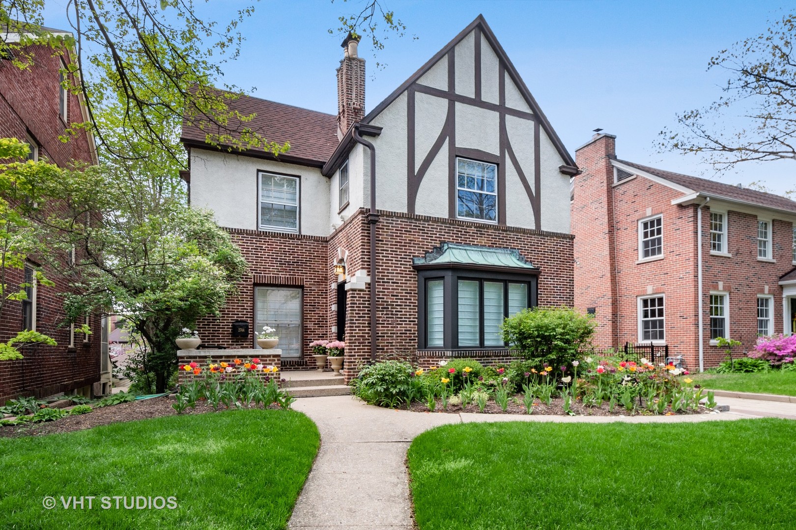 a front view of a house with a yard and potted plants