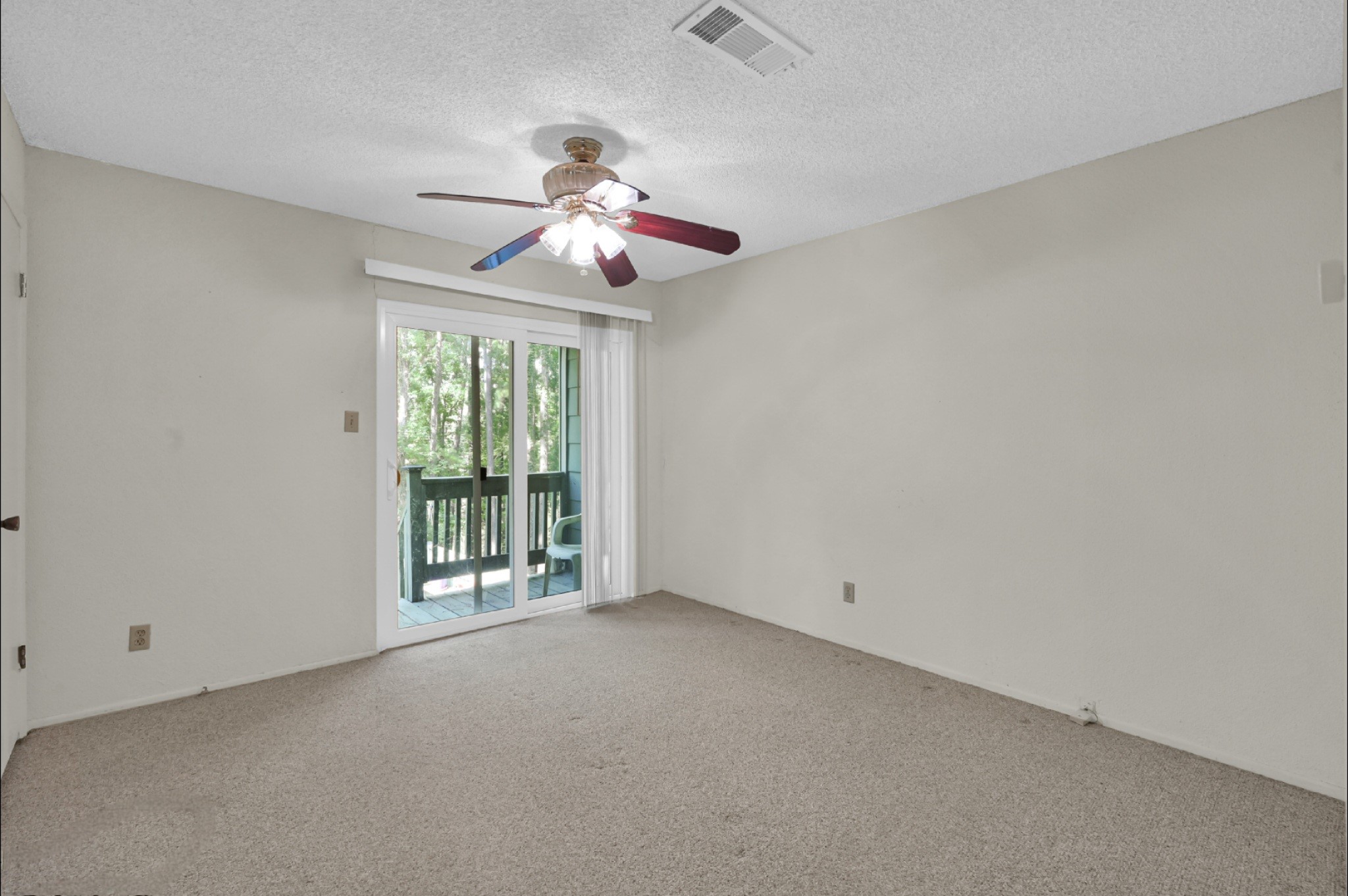 162 Villa Way Coldspring, TX 77331 - Photo 16 of 42 an empty room with chandelier fan and windows