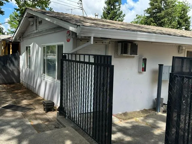 a view of a house with a small yard and wooden fence