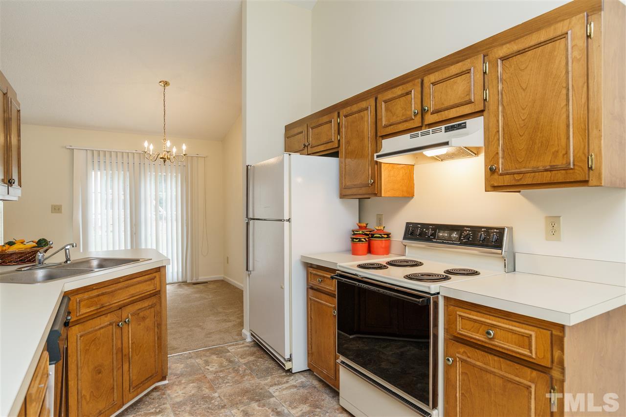 2301 Carthage Circle Raleigh, NC 27604 - Photo 8 of 17 a kitchen with stainless steel appliances a stove a sink dishwasher and a refrigerator with wooden cabinets
