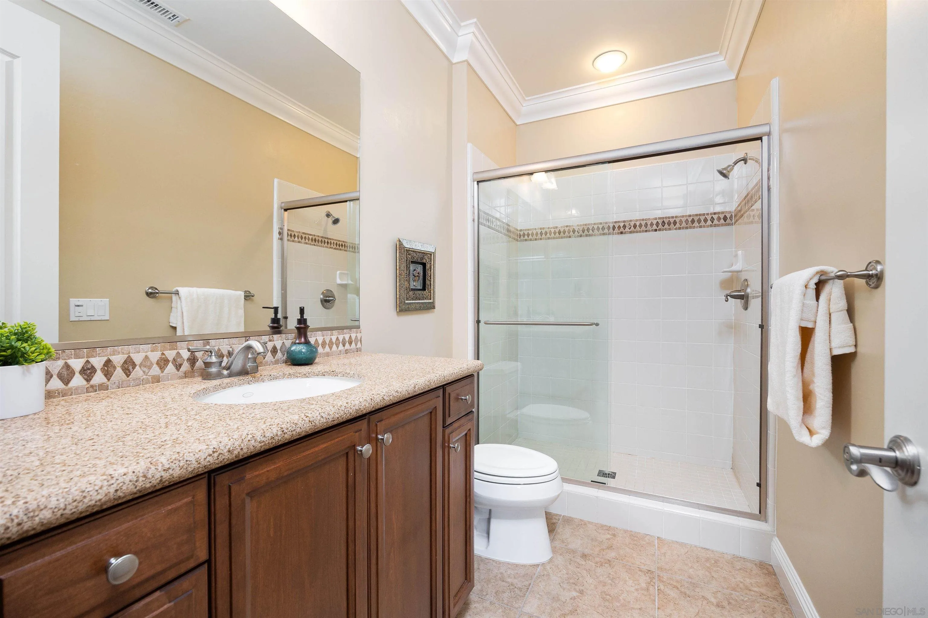 14803 Whispering Ridge Road San Diego, CA 92131 - Photo 30 of 41 a bathroom with a granite countertop sink toilet and shower