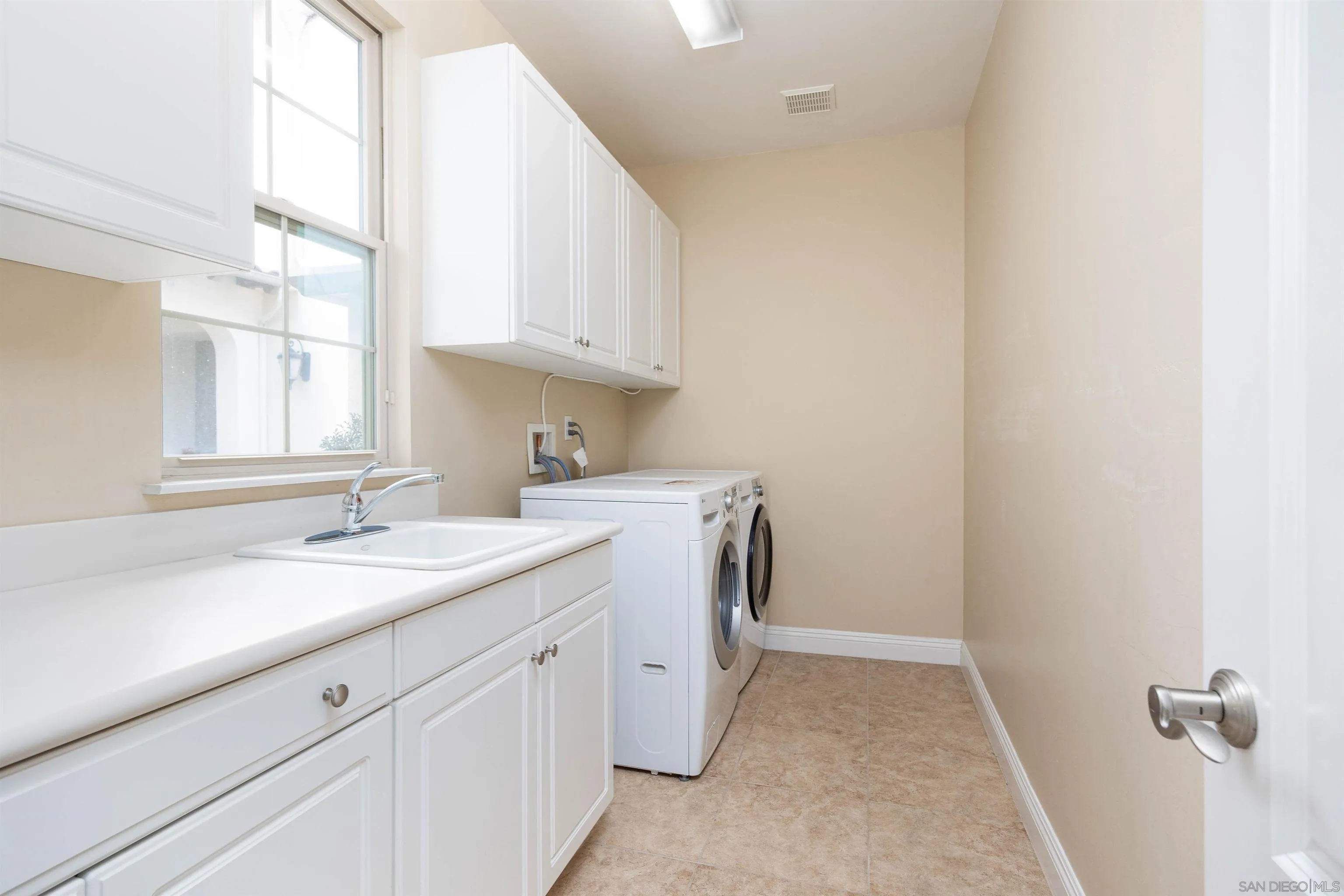 14803 Whispering Ridge Road San Diego, CA 92131 - Photo 35 of 41 a utility room with cabinets washer and dryer